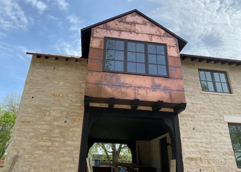 Copper metal panel facade on a stone building for Skylight Installation in International Falls